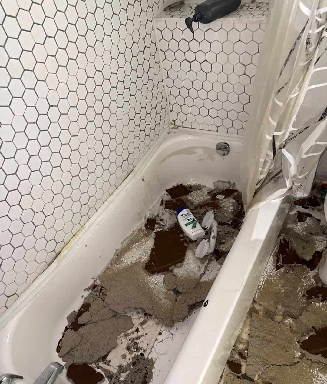 Bathtub filled with fallen wet ceiling material after a water line break above